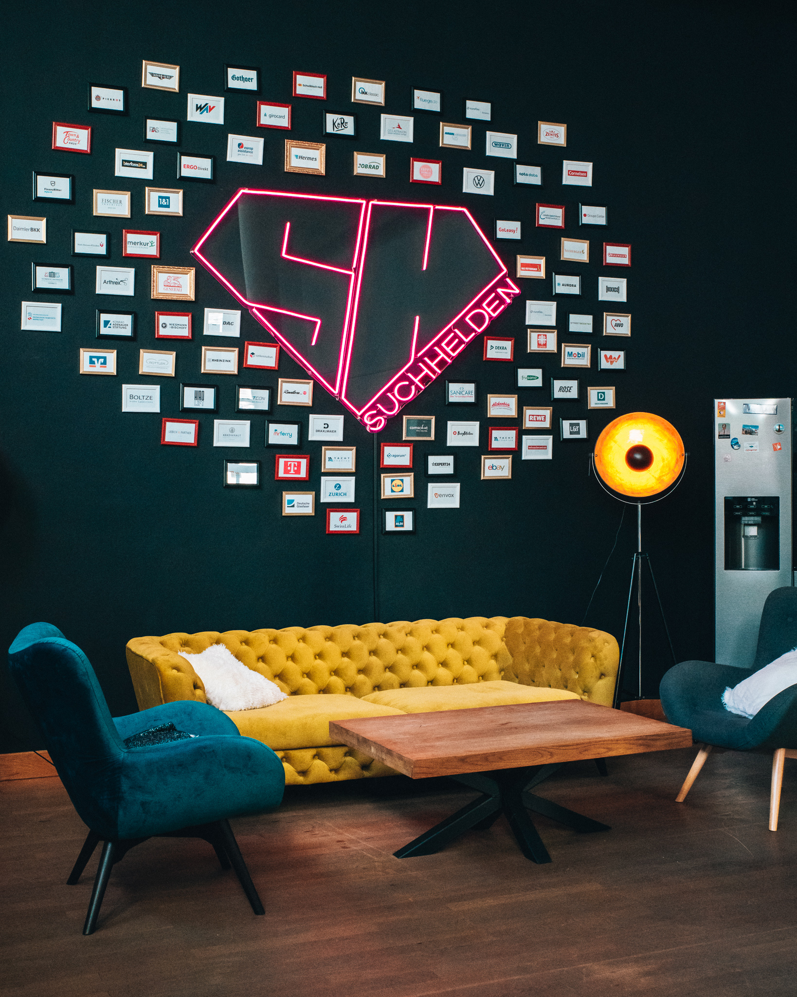 Suchhelden Hall of Fame Wand mit gerahmten Kundenlogos und Neon-Diamant im Osnabrücker Büro