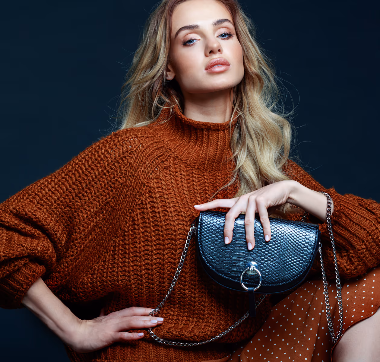 Junge Frau im Herbst-Look mit Strickpullover und Tasche